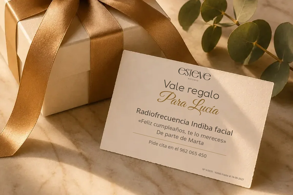 Example of an Esteve Estudio gift voucher: a personalised “For Lucía” card next to a box with a golden ribbon